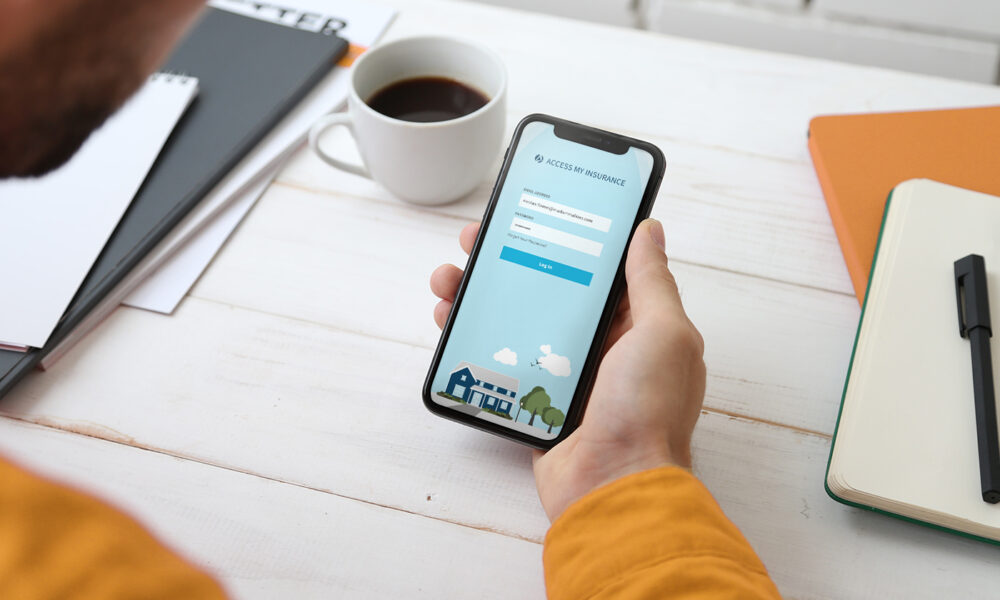 man holding phone with app log in screen visible